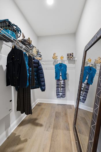 A row of coats are hanging on a rack in a room.